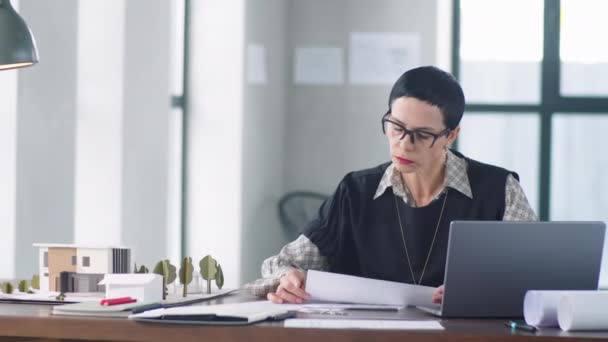 Arquitecta Profesional Con Pelo Corto Morena Sentada Escritorio Oficina Leyendo — Vídeos de Stock