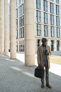 İş adamı açık havada telefon kullanıyor.