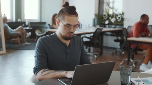 Arco Tiro Jovem Caucasiano Desgaste Casual Óculos Trabalhando Laptop Mesa — Vídeo de Stock
