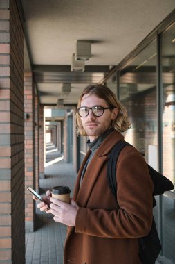 Dışarıda kahvesi olan bir iş adamı.