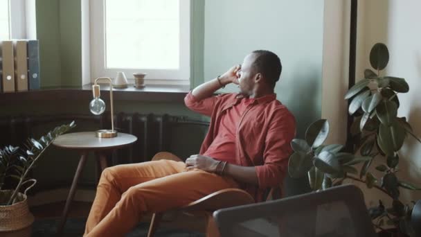 Mladý Afroameričan Ležérní Oblečení Opírající Pohodlnou Židli Mluvení Mobilním Telefonu — Stock video