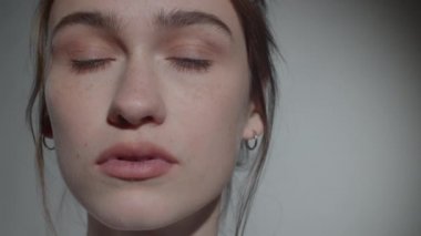 Stüdyoda kameraya makyaj yapmadan poz veren güzel beyaz kadın portresi.