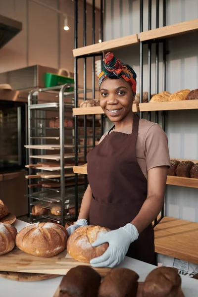 Dueño sonriente en uniforme en la panadería — Foto de Stock