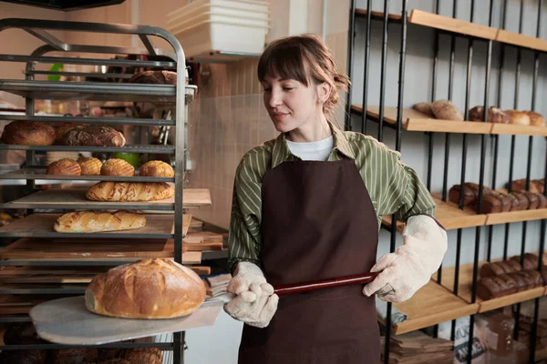 Mladá žena pečení chleba v troubě — Stock fotografie