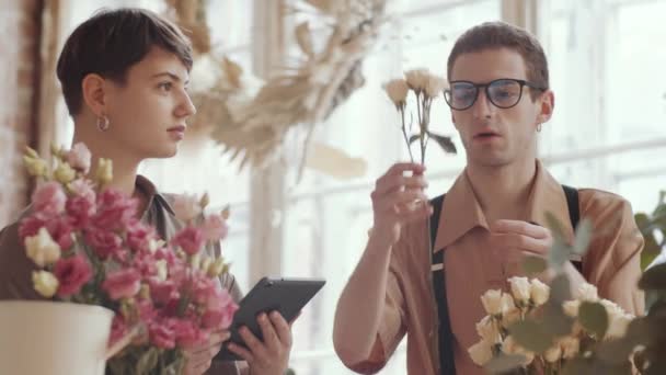 Muž Květinářství Zástěře Vysvětluje Něco Ukazuje Růže Mladé Veselé Ženě — Stock video
