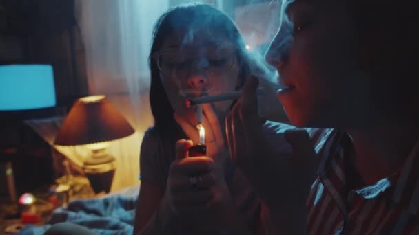 Duas Jovens Namoradas Acendendo Cigarros Fumando Quarto Escuro Enquanto Descansam — Vídeo de Stock