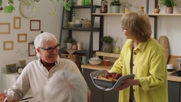 Cheerful Elderly Woman Bringing Freshly Cooked Dish Dinner Table Smiling — Stock Video