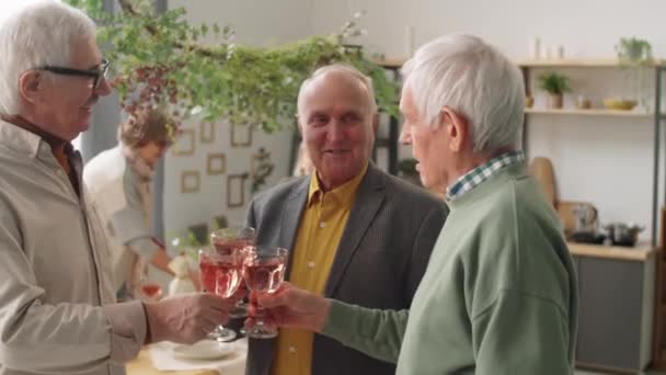 有三个积极的老年人陪在一起 一边举杯 一边在家里和朋友们一起举杯喝酒 — 图库视频影像