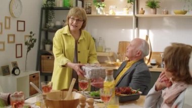 Mutlu, son sınıf öğrencisi bir kadın hediye kutusu veriyor, dilek diliyor ve kocasını kucaklıyor, arkadaşları da evde doğum günü yemeğinde el çırpıyor.