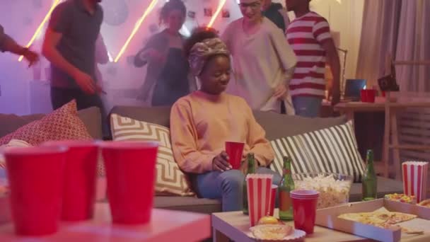 Mujer Afroamericana Aburrida Sentada Sofá Con Bebida Mientras Amigos Felices — Vídeos de Stock