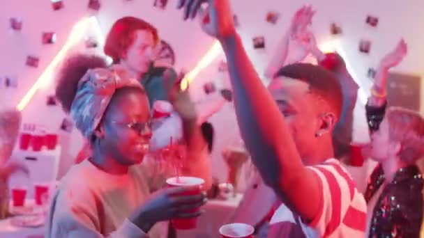 若い幸せなアフリカ系アメリカ人のカップルは 多民族の友人のグループと一緒にホームパーティーで笑顔と踊ります — ストック動画