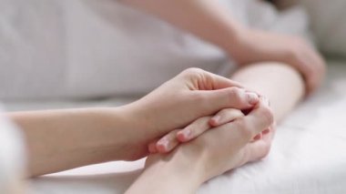 Kadın hastanın elini tutan ve okşayan kadının seçici odak fotoğrafını çek. Hastalık sırasında onu desteklerken.