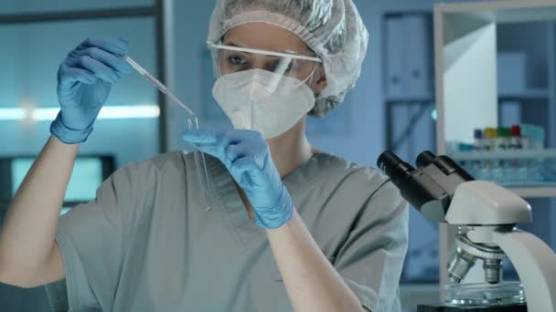 Tilt Shot Van Vrouwelijke Wetenschapper Beschermende Masker Handschoenen Glazen Gieten — Stockvideo