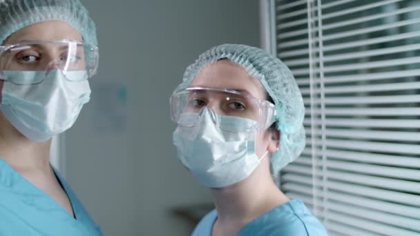 Toma Pecho Dos Doctores Con Máscaras Protectoras Gafas Sombreros Estériles — Vídeo de stock