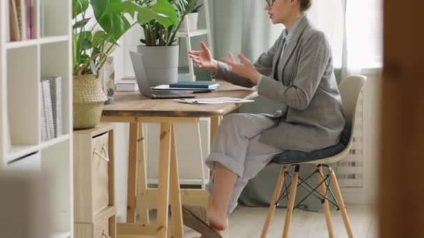 穿着舒适拖鞋 睡衣裤 正式衬衫和夹克的女人坐在桌旁 一边讨论视频文件 一边在家里举行远程商务会议 一边进行检疫 — 图库视频影像