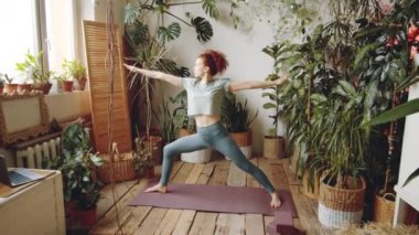 Tozluklu ve tişörtlü genç güzel bir kadının spor salonunda yoga yaparken sporcu pozu çalışmasını yakınlaştır.