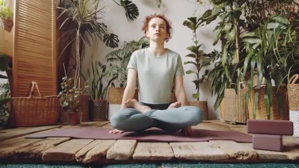 요가가 초록색 식물들 방에서 일하는 운동복을 포즈를 취하고 여성의 사진을 — 비디오