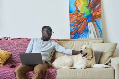 Evde dizüstü bilgisayar kullanan bir adam