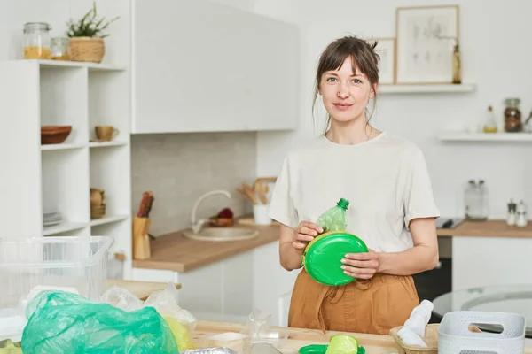 Женщина сортирует пластик на кухне — стоковое фото