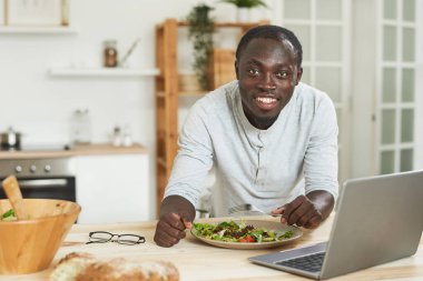 Adam öğle yemeği sırasında çalışıyor.