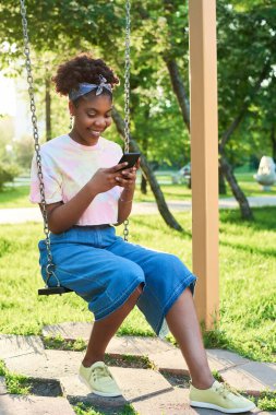 Parkta cep telefonu kullanan bir kadın.