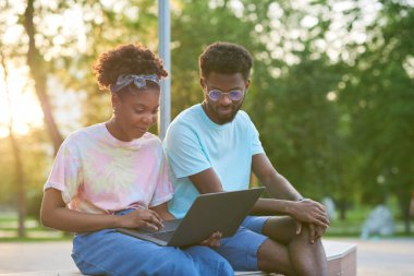 Arkadaşlar dışarıda dizüstü bilgisayar kullanıyor