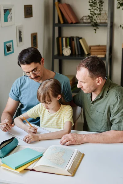 Дівчина робить домашнє завдання з батьками — стокове фото