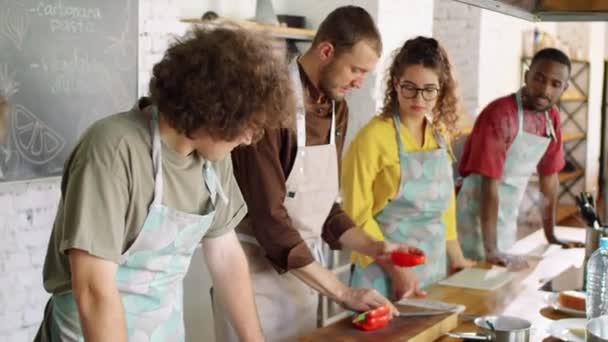 Chef Masculin Coupant Poivron Rouge Donnant Des Parties Divers Jeunes — Video