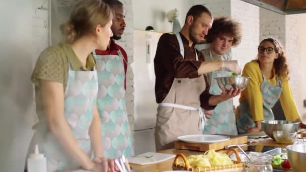 Chef Masculin Tablier Gants Mélangeant Ingrédient Salade Dans Bol Expliquant — Video