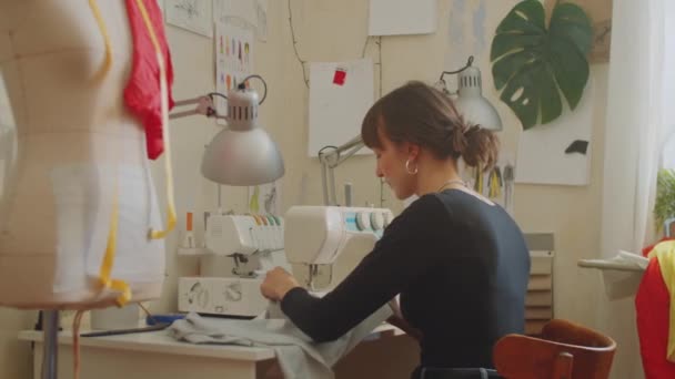 Female Dressmaker Using Sewing Machine While Working New Clothes Atelier — Stock Video