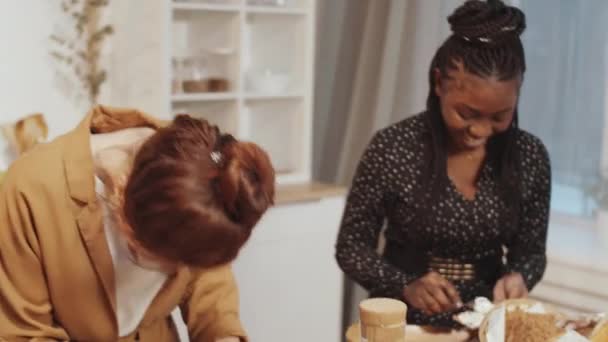 三位多民族女性朋友站在厨房餐桌边 一起做饭 一边聊天 一边笑 手持相机拍照 — 图库视频影像