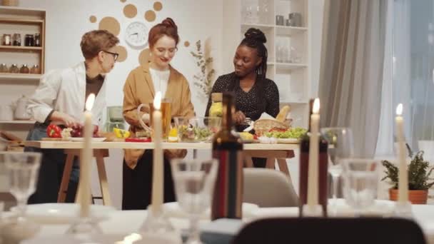 2人の白人女性と彼らのアフリカ系アメリカ人女性の友人笑顔と家での休日の夕食のために一緒に料理をしながらチャット — ストック動画