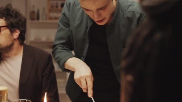 Genç Misafirperver Adam Çatal Bıçak Kullanırken Akşam Yemeği Partisindeki Arkadaşları — Stok video