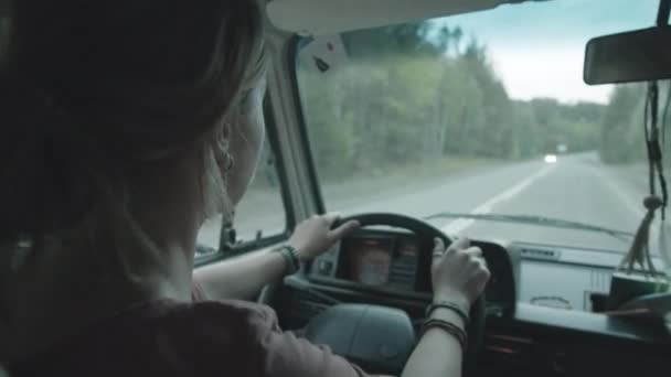 从妇女驾驶汽车的后座观看 而可爱的金毛猎犬躺在乘客座位上 — 图库视频影像