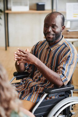 İş arkadaşlarıyla konuşan engelli bir adam