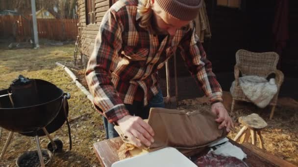 Man Beanie Hat Lumberjack Shirt Unrolling Bag Checking Knives While — Stock Video