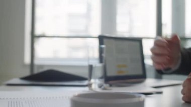 Tanımlanamayan Afro-Amerikalı iş adamının ofis masasında yan yana otururken Kafkasyalı iş arkadaşına el sıkışırken yakın çekim.