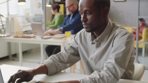 Afroamerykanin Ubraniu Casualwear Korzystający Laptopa Dokumentu Czytania Podczas Pracy Biurze — Wideo stockowe