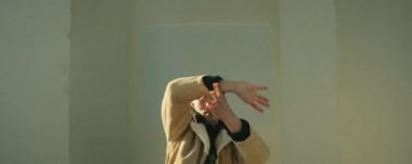 Sokak dansçısının anamorfik görüntüsü. Açık havada kameraya bakıyor ve kollarını hareket ettiriyor.