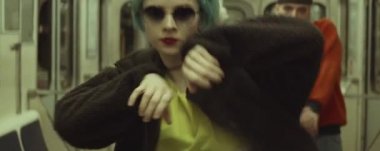 Trende dans eden ve dans ekibinin önünde dans eden modaya uygun kıyafetli ve güneş gözlüklü genç bayan dansçının anamorfik görüntüsü.