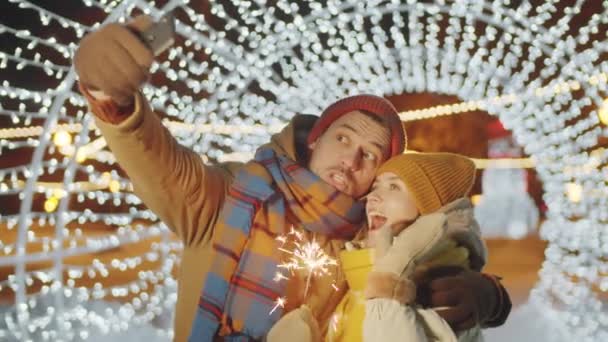 Gioioso Giovane Coppia Possesso Natale Scintillante Abbracciando Posa Fotocamera Smartphone — Video Stock