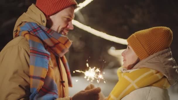 Pareja Romántica Ropa Abrigo Sosteniendo Chispas Navidad Mirándose Los Ojos — Vídeos de Stock