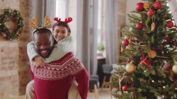 집에서 크리스마스 장식을 밴드에 기쁜아 미국인 아버지가 딸에게 피기백을 — 비디오