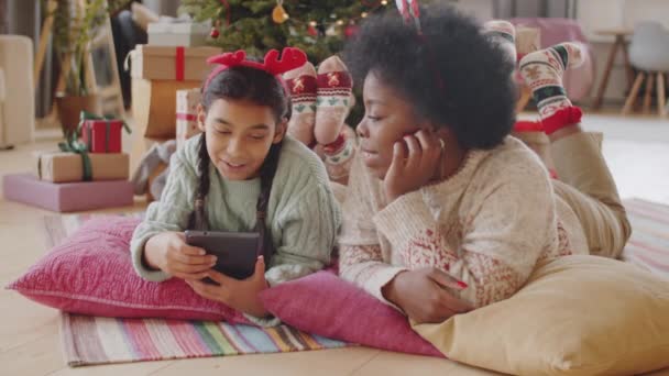 크리스마스 머리띠를 바닥에 디지털 태블릿 대화를 나누는 즐거운아 미국인 어머니와 — 비디오
