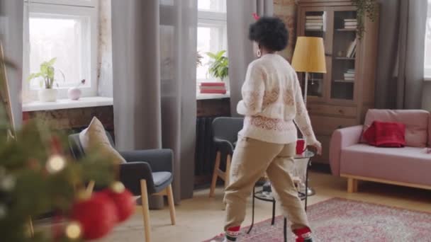 Afro Amerikaanse Vrouw Kerst Hoofdband Lopen Woonkamer Zitten Een Fauteuil — Stockvideo