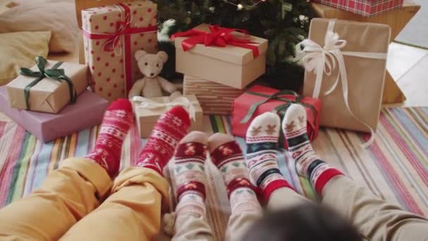 Familjens Ben Semesterstrumpor Sitter Tillsammans Golvet Nära Julklappar Träd Och — Stockvideo