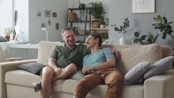 中长镜头 现代白人恋爱中的男人坐在客厅沙发上谈论着什么 — 图库视频影像