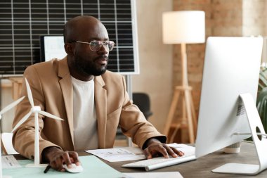 Ofisteki bilgisayarda çalışan tasarımcı