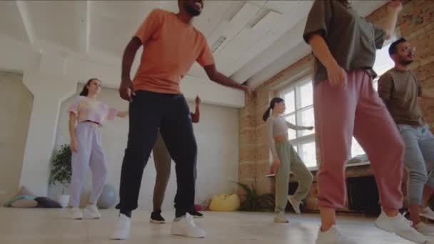 若い多民族の男性と女性のPanスポーツウェア学習の動きと女性教師とともにダンス教室でスタジオ — ストック動画