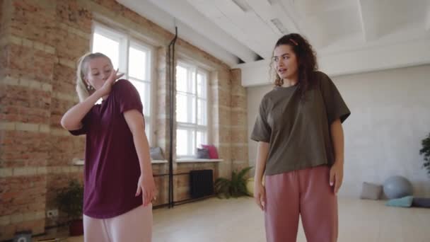 スタジオでのプライベートダンスの授業中に若い女性に腕の動きを説明する女性インストラクター — ストック動画